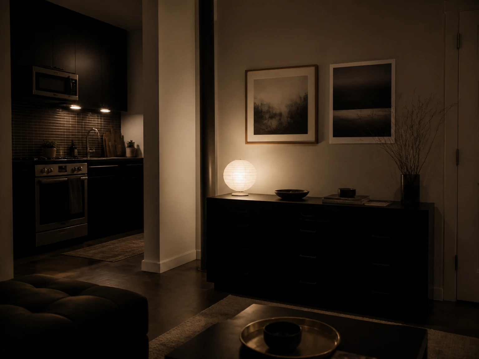Finished rental wall with light framed art and an unframed print arranged above dark furniture