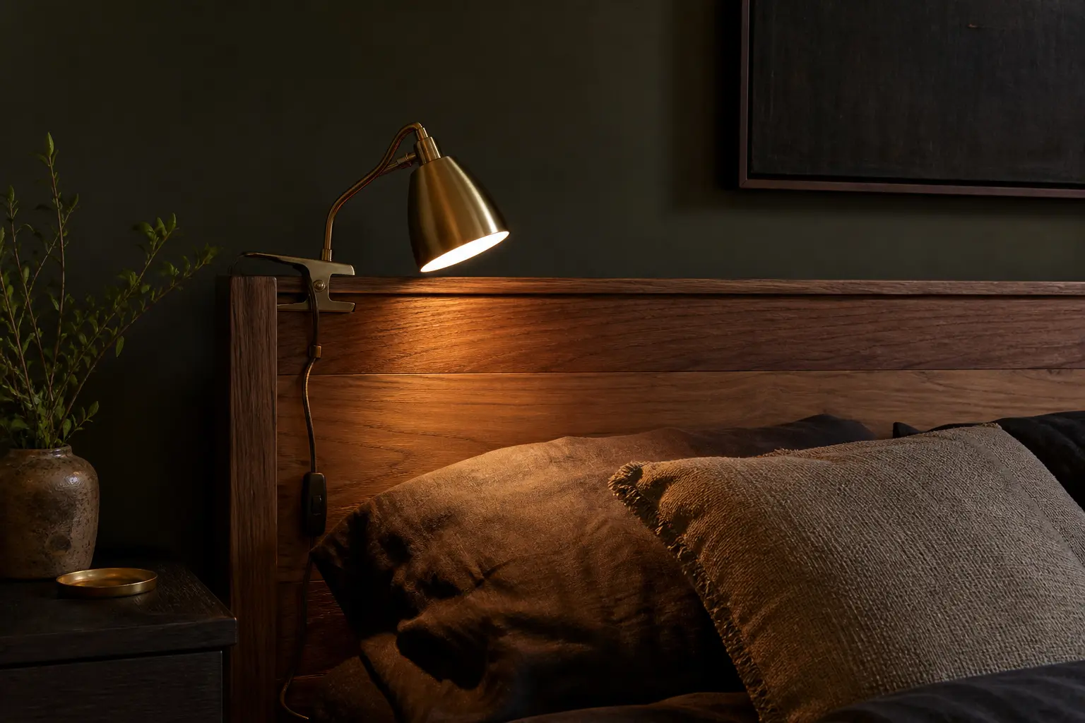 Warm plug-in clamp light attached to a renter bedroom headboard without wall damage